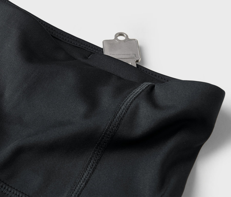 Detailaufnahme von schwarzen Leggings mit Schlüssel in der Tasche.