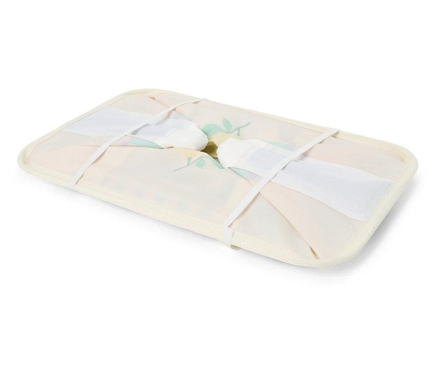 Zusammengeklappter, blumenmusterbezogener Wäschekorb mit weißen Bändern.