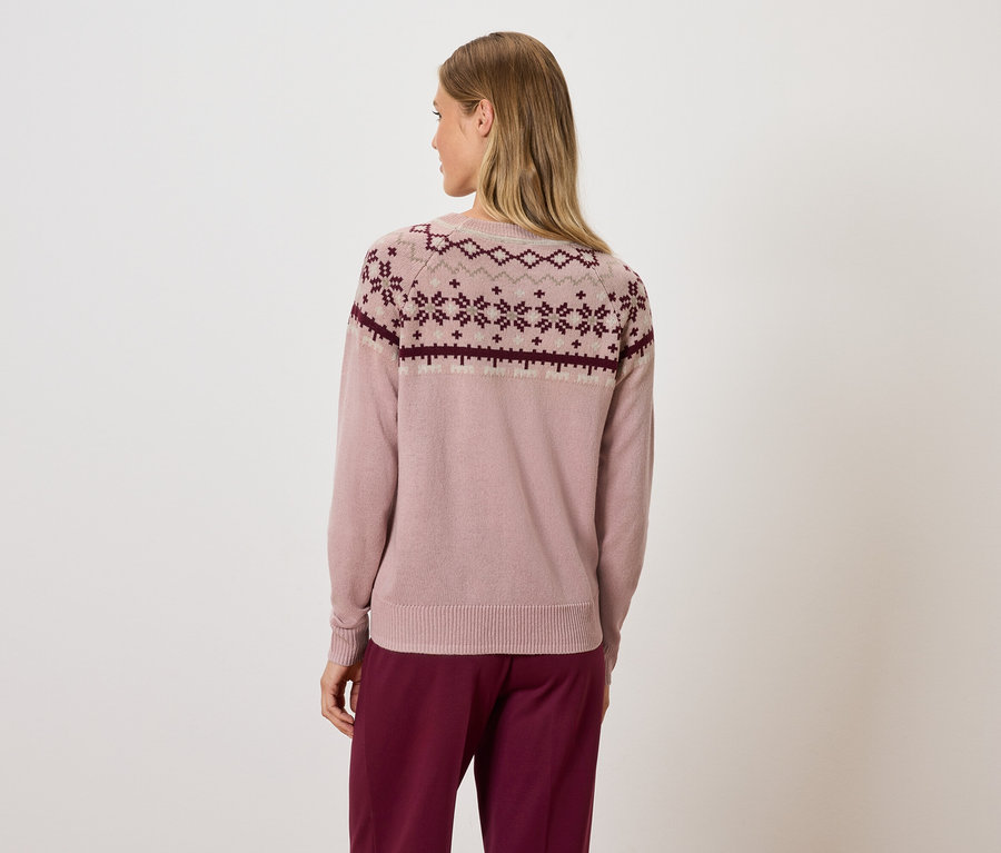 Frau von hinten in rosa Pullover mit geometrischem Muster und bordeauxfarbener Hose.