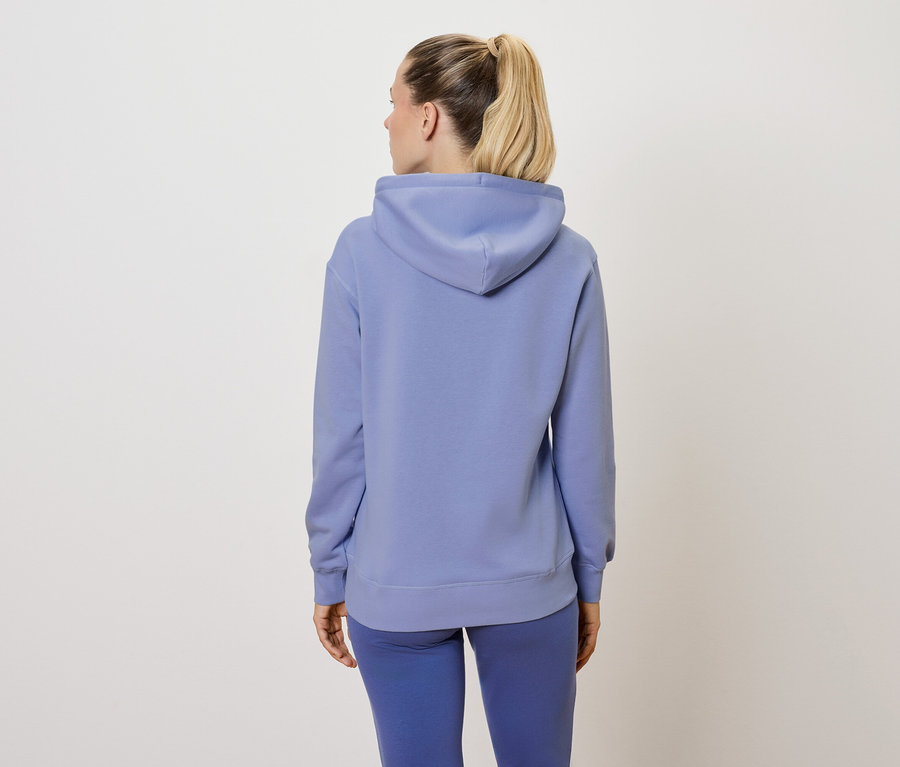 Frau von hinten in einem blauen Trainingsanzug.