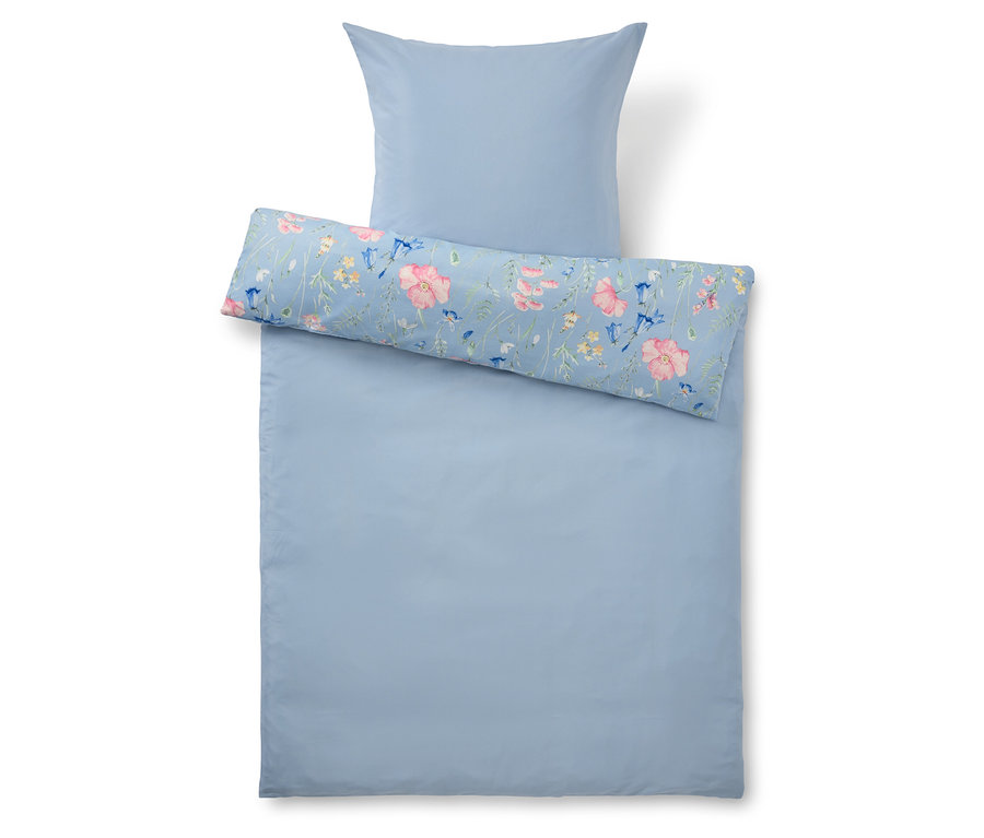 Draufsicht auf ein hellblaues Bettwäsche-Set mit einem floral gemusterten Kissenbezug.