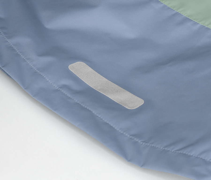 Detailaufnahme einer blau-grünen Jacke mit einem reflektierenden Streifen an der Seite.