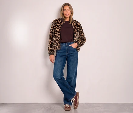 Eine Frau trägt einen Street One Blouson mit Leopardenmuster über einem braunen Oberteil, weite Jeans und braune Schnürschuhe.