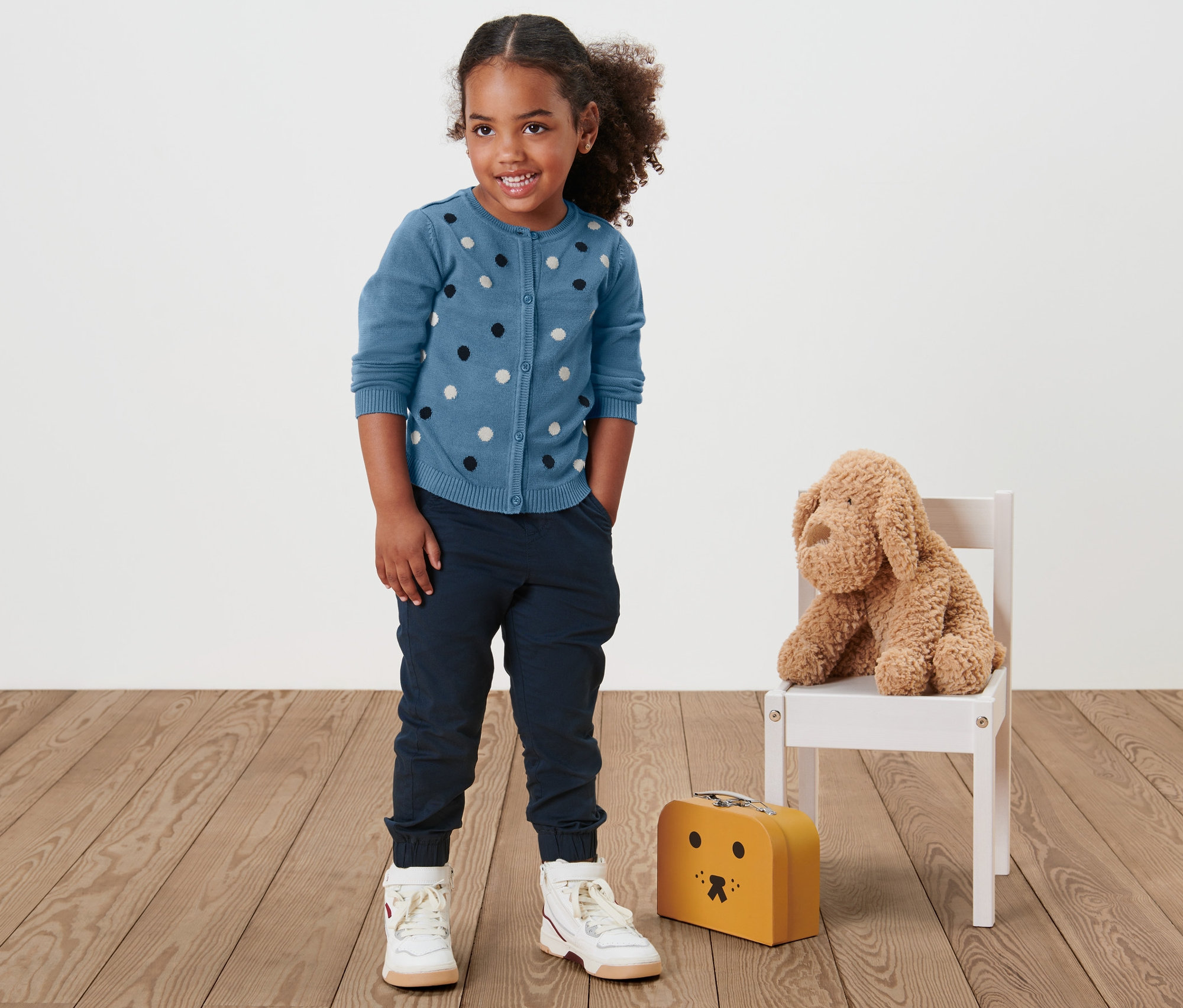 Mädchen trägt eine Kleinkind-Strickjacke.