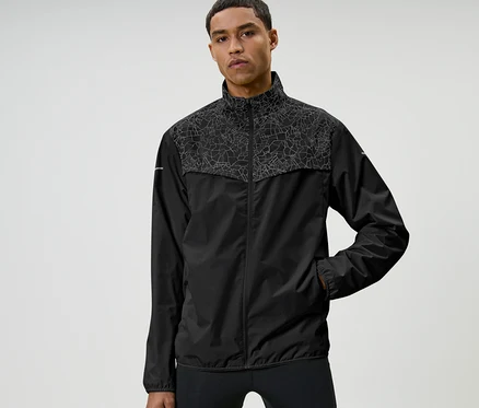 Mann posiert in Windprotection-Laufjacke, schwarz.