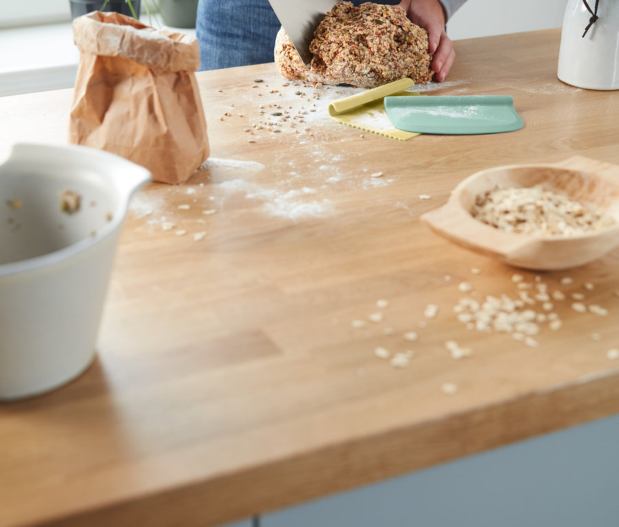 Person schneidet Brot mit einem Profi-Backhelfer-Set.