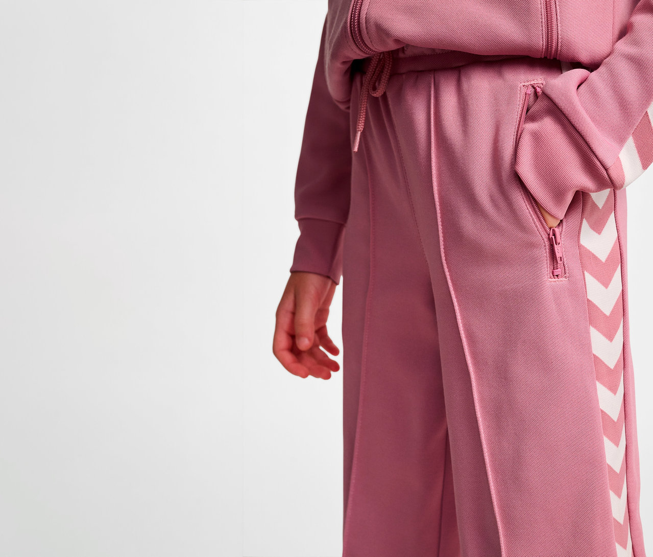 Person hat Hand in der Tasche der weiten HUMMEL HMLJR Archive Poly Hose.