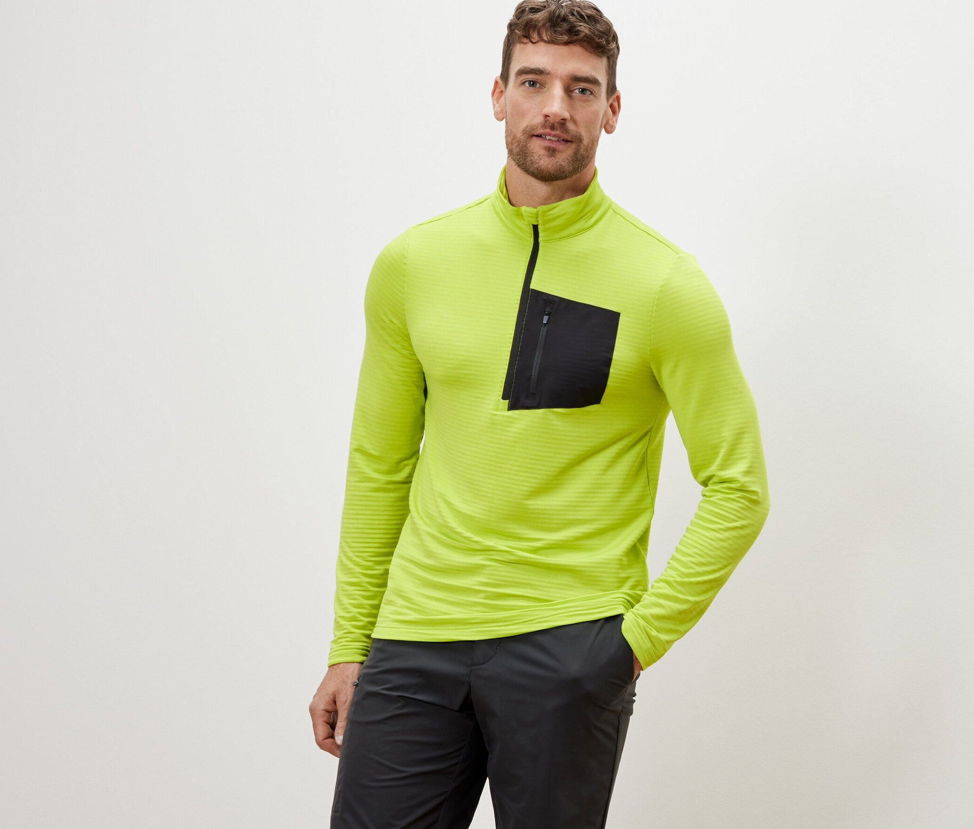 Mann posiert in einem limefarbenen Outdoor-Funktionsshirt.