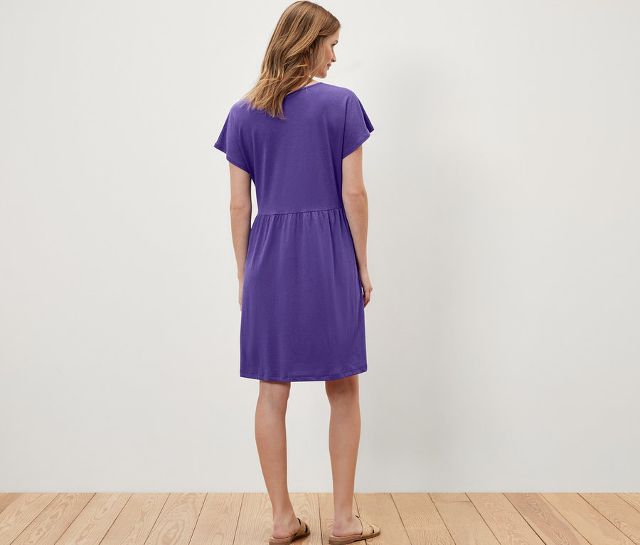 Frau trägt ein lila Jerseykleid.