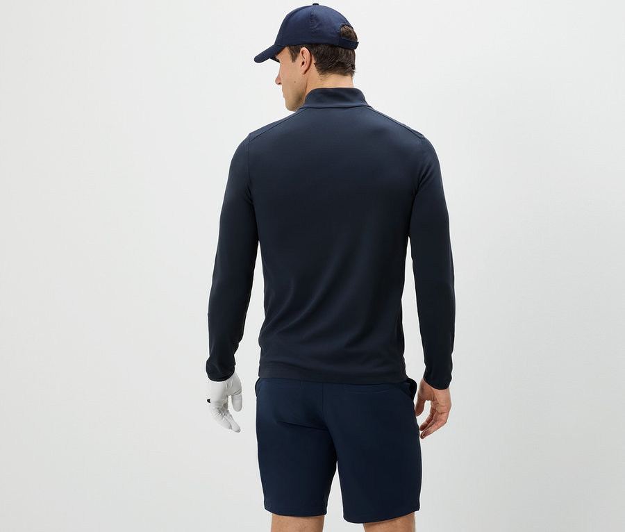 Mann von hinten trägt eine Funktionsjacke, Shorts und eine Kappe.