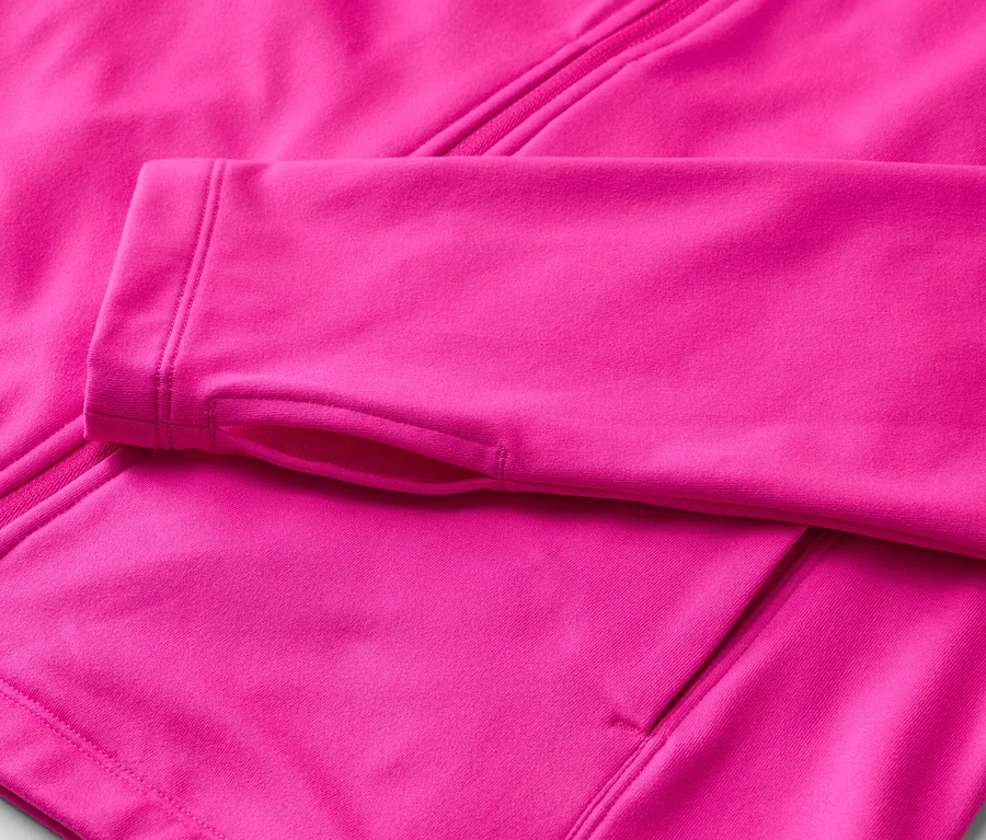 Nahaufnahme einer pinkfarbenen Fleecejacke mit Reißverschluss und Daumenlöchern am Ärmel.