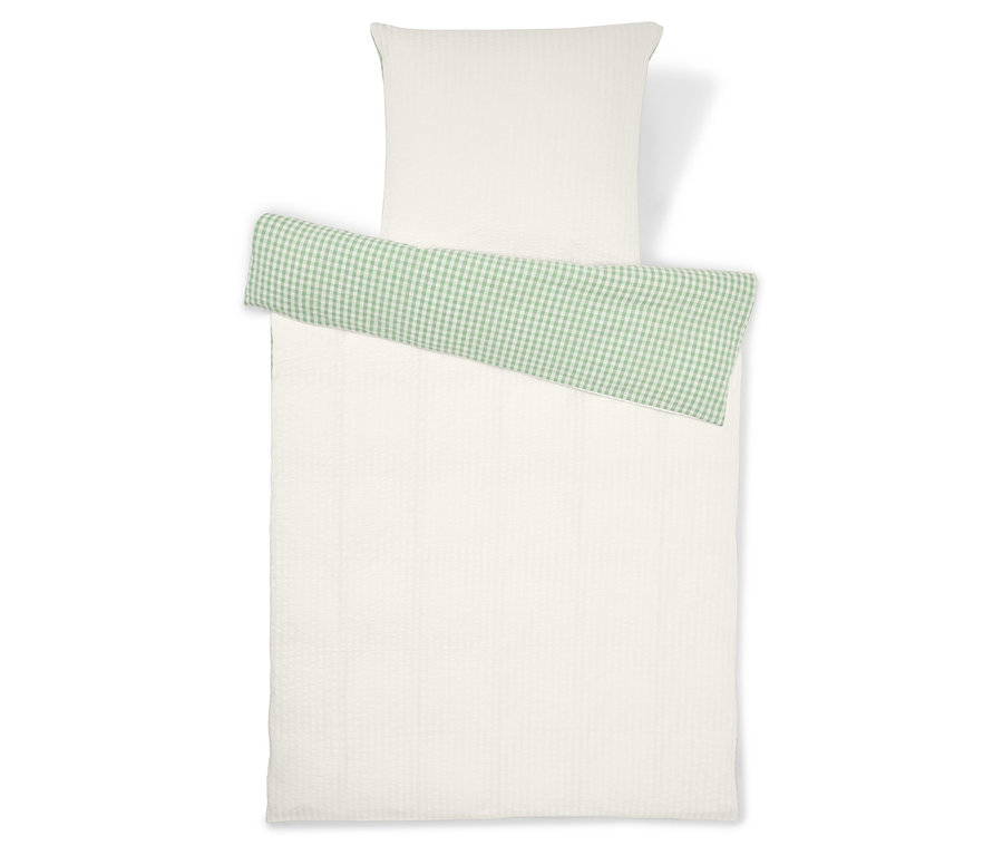 Bettwäsche-Set, bestehend aus einem weißen Kissenbezug und einem weißen Bettbezug mit einem grünen, karierten Detail.