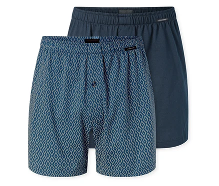 Zwei SCHIESSER Jersey-Boxer; einer blau mit weißem Rautenmuster und Knopfleiste, der andere unifarben dunkelblau.