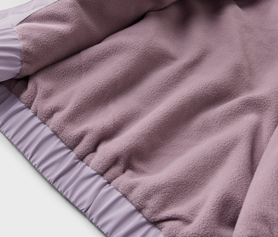 Nahaufnahme der Innenseite einer lila Jacke mit Fleece-Futter und elastischen Bündchen.