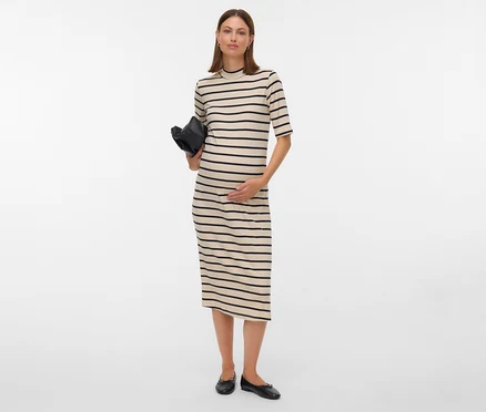 Schwangere Frau in gestreiftem Kleid hält eine schwarze Tasche.