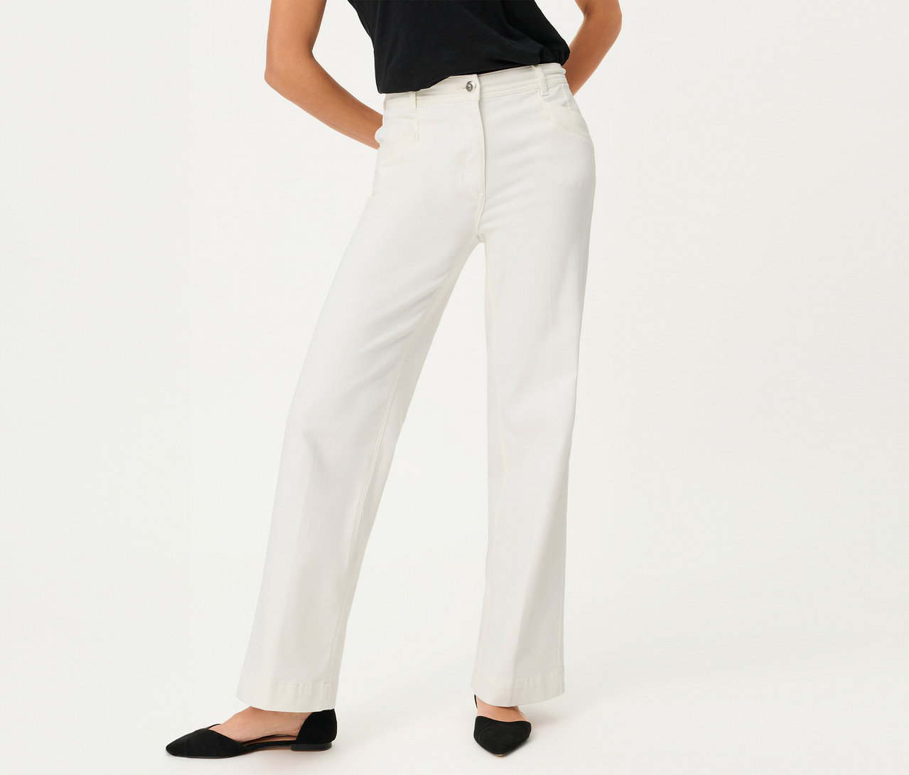 Frau trägt Olsen Wide Leg Jeans und schwarze Schuhe vor einem weißen Hintergrund.
