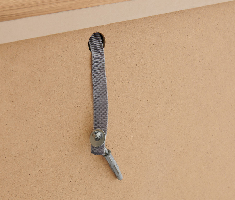 Detail der Wandbefestigung des Highboards »Clara« mit Schubladen mit Schraube und Gurt.