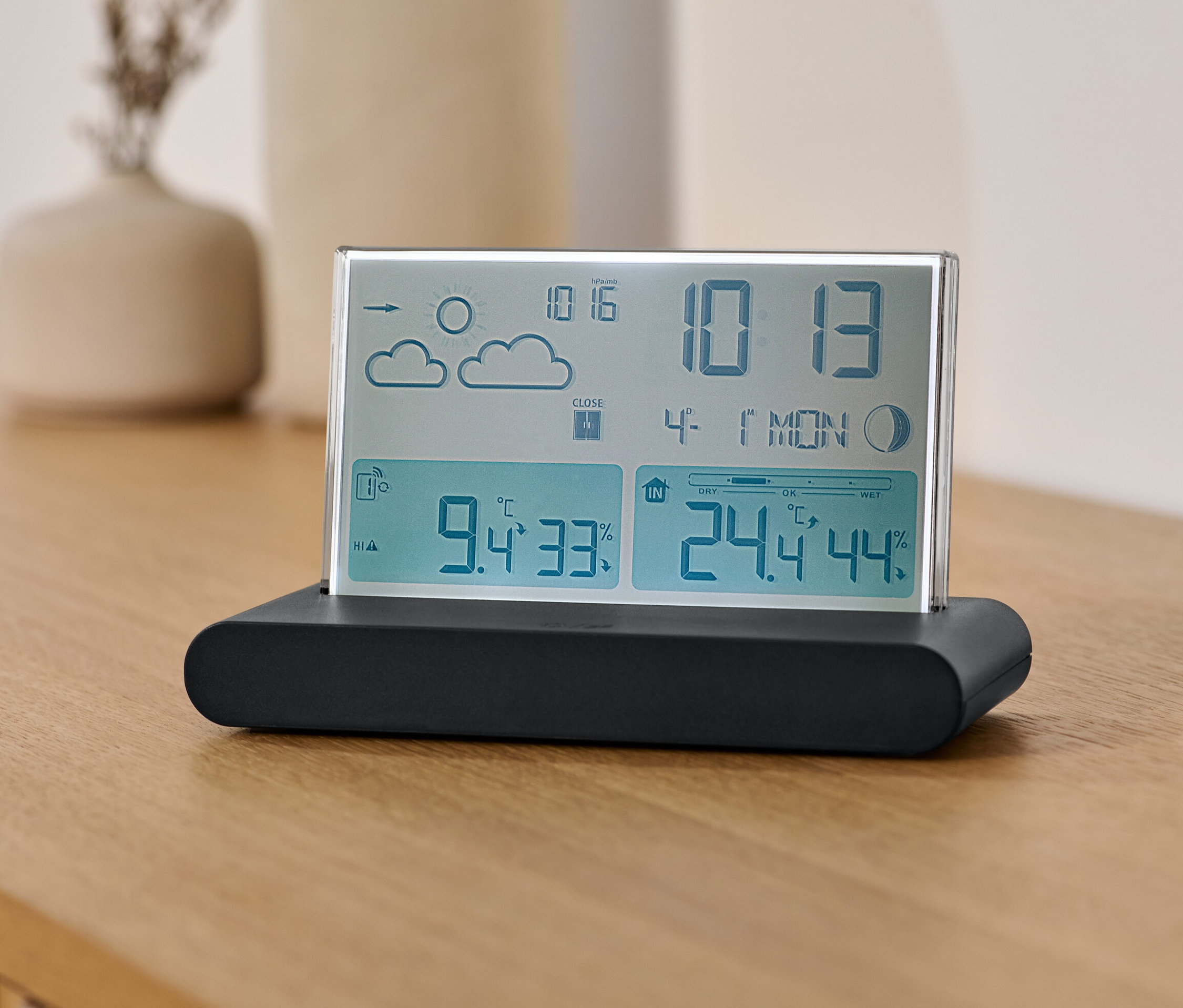 Eine Funk-Wetterstation mit Außensensor steht auf einem Holztisch.