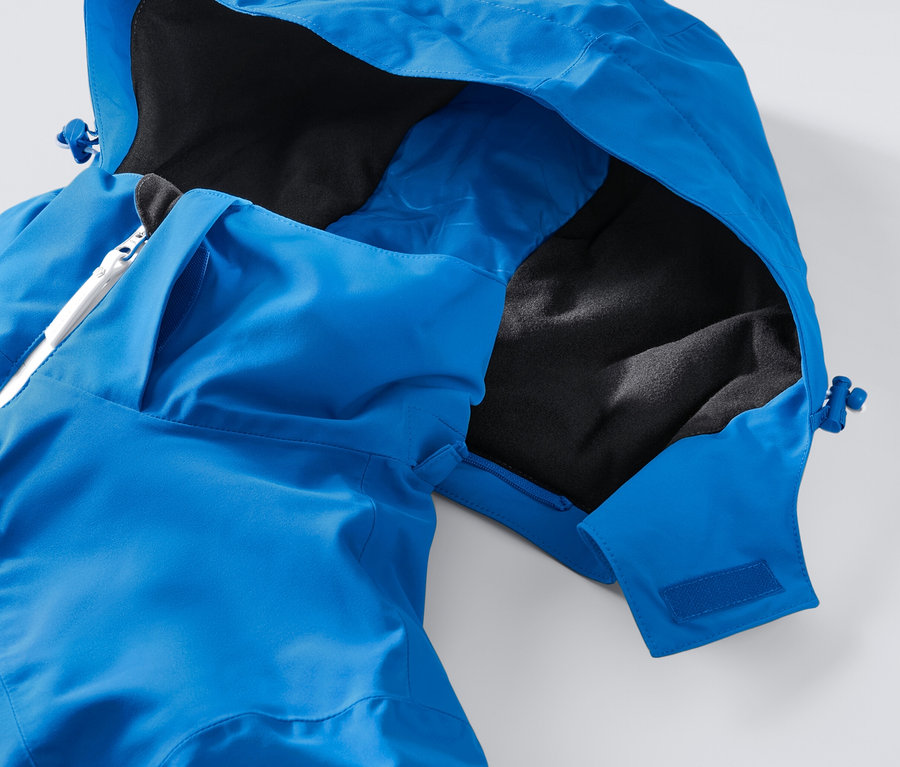 Detailansicht einer blauen High-Tech-Skijacke mit Kapuze und weissem Reissverschluss.