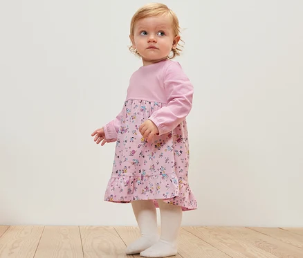 Kleinkind trägt ein Baby-Jerseykleid.