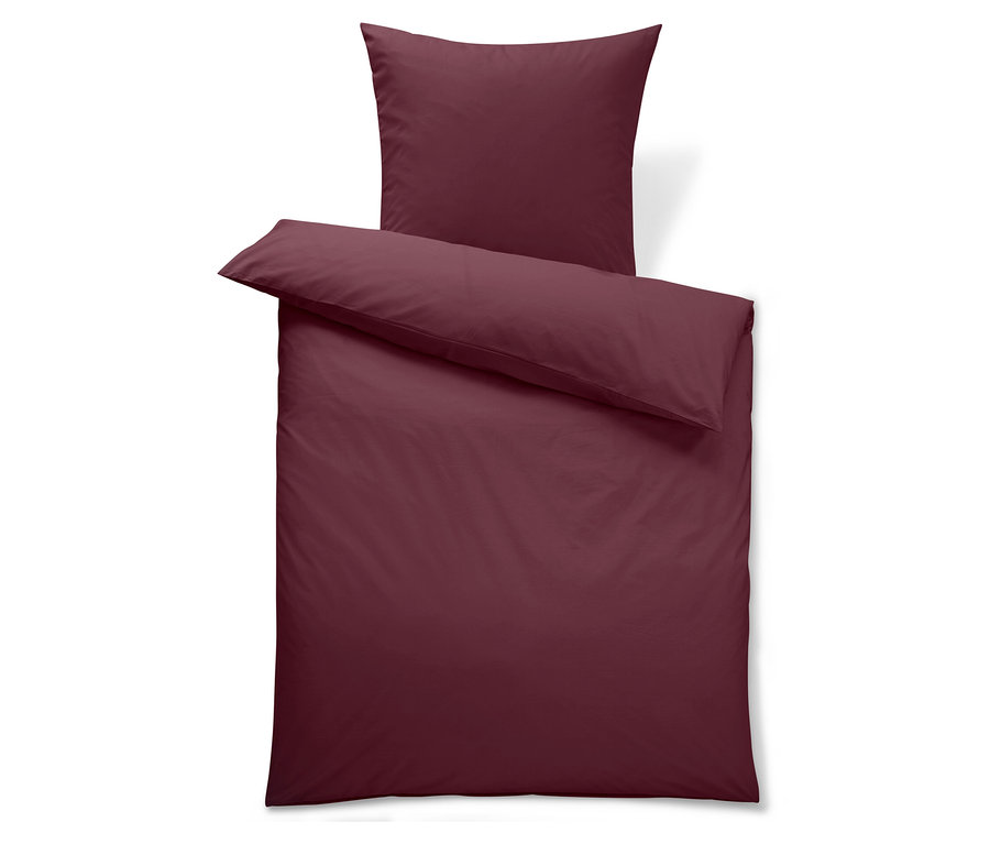 Weinrote Bettwäsche mit Kissen.