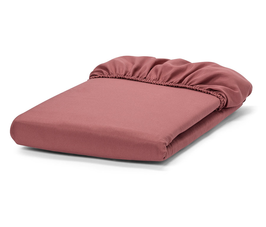 Zusammengefaltetes rosafarbenes Spannbettlaken.