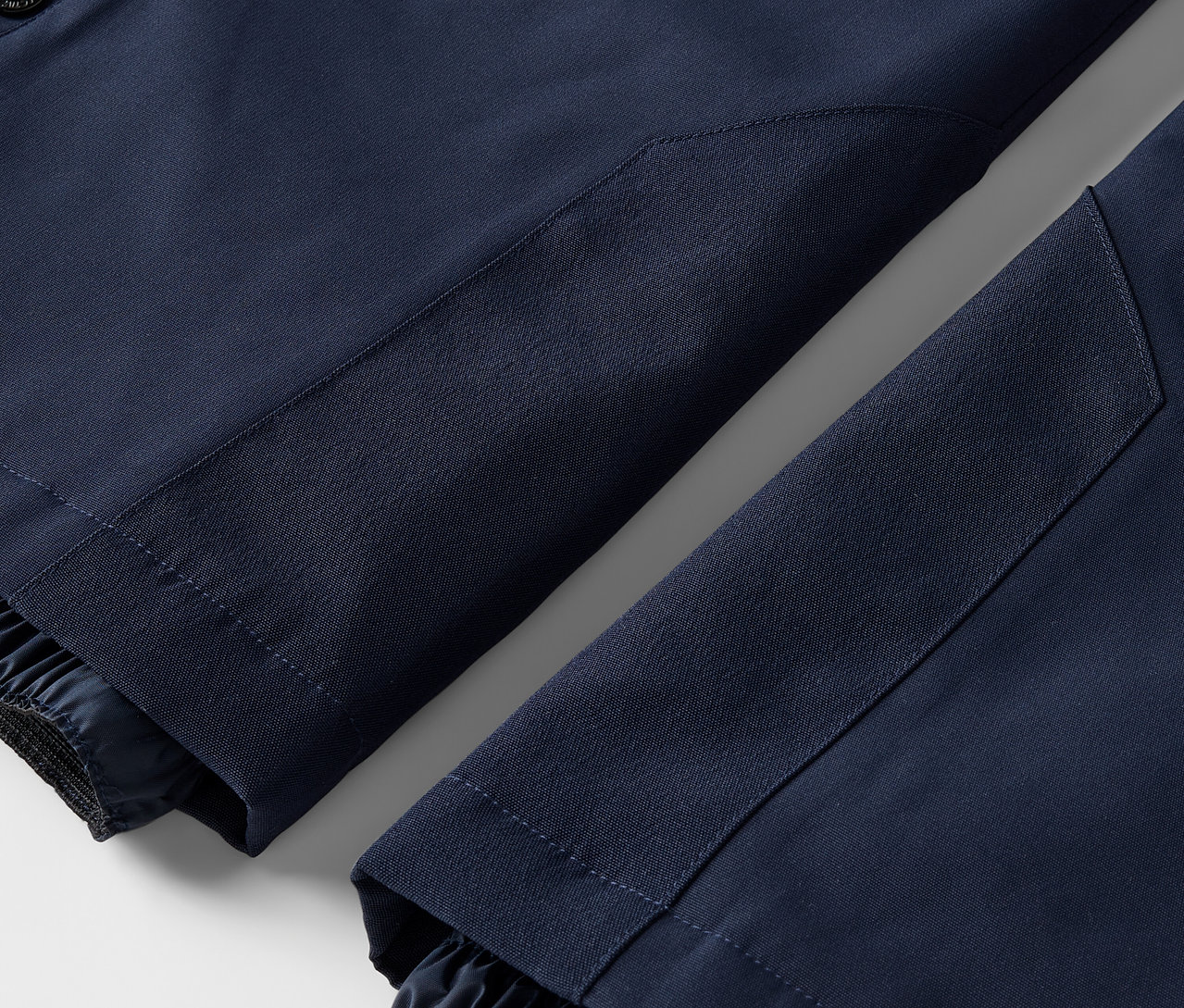 Detailansicht von zwei marineblauen Hosenbeinen mit elastischen Bündchen.