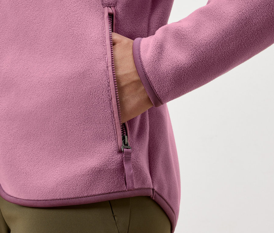 Hand in der Tasche einer pinken Fleecejacke mit Reißverschluss.