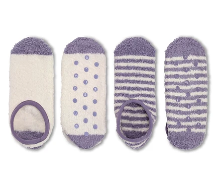 Vier Paar flauschige Socken in Weiß und Lila.