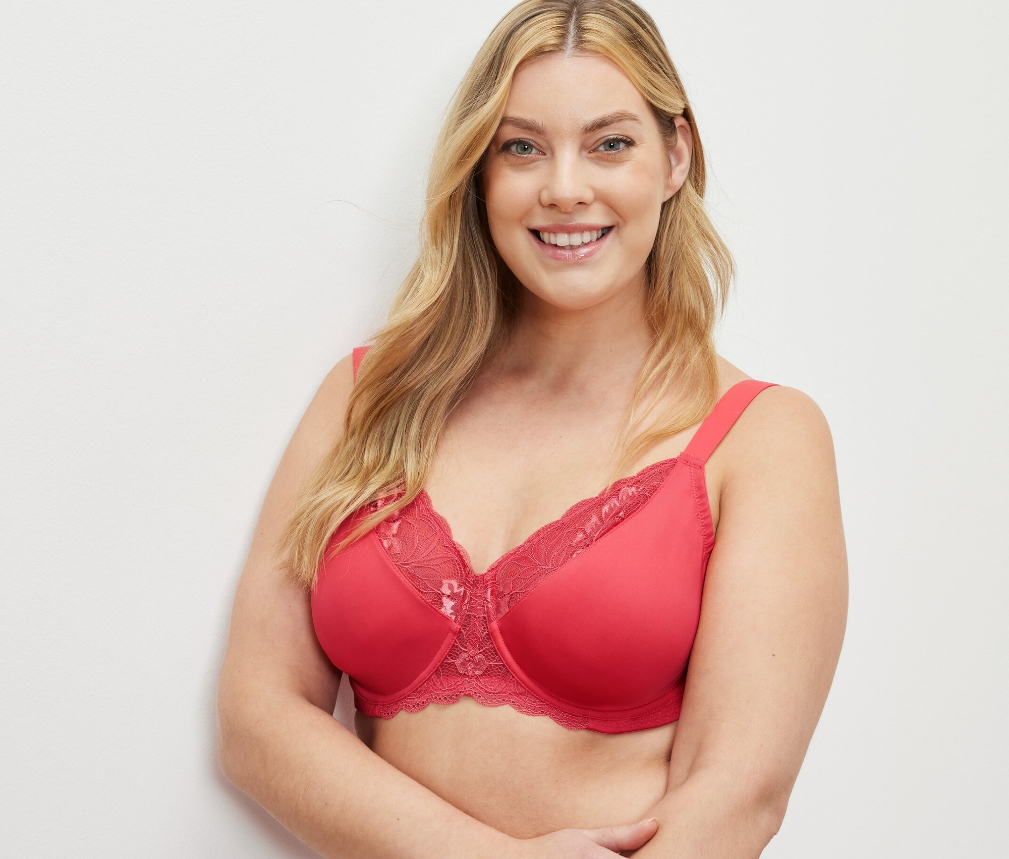 Lächelnde Frau trägt einen roten Minimizer-BH.