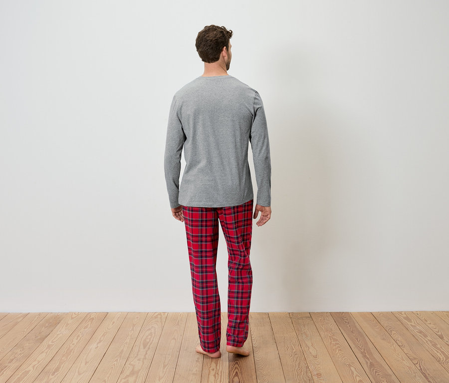 Mann von hinten trägt ein graues Langarmshirt und eine rot karierte Hose.