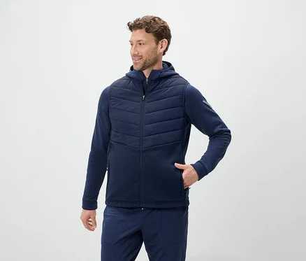 Mann trägt eine blaue Weste mit Kapuze und eine blaue Jogginghose.