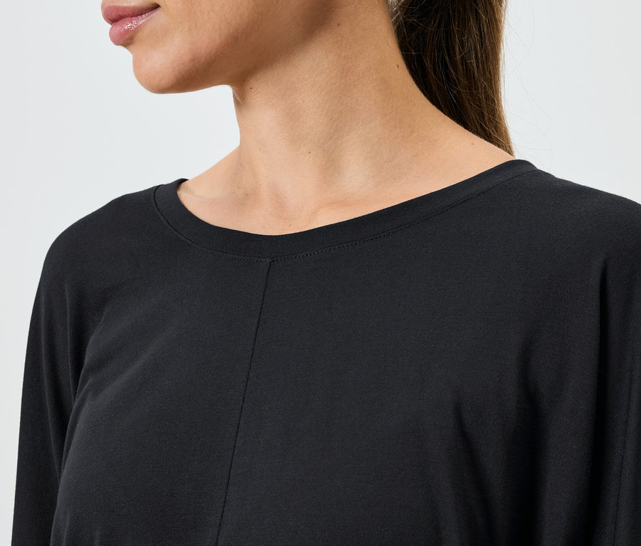 Detailaufnahme eines schwarzen Damenoberteils mit langen Ärmeln.