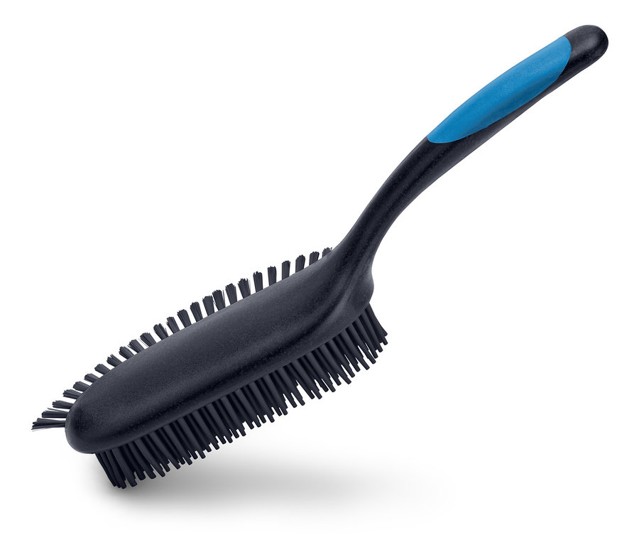 Eine schwarze Bürste mit blauem Griff liegt diagonal auf einem weißen Hintergrund.