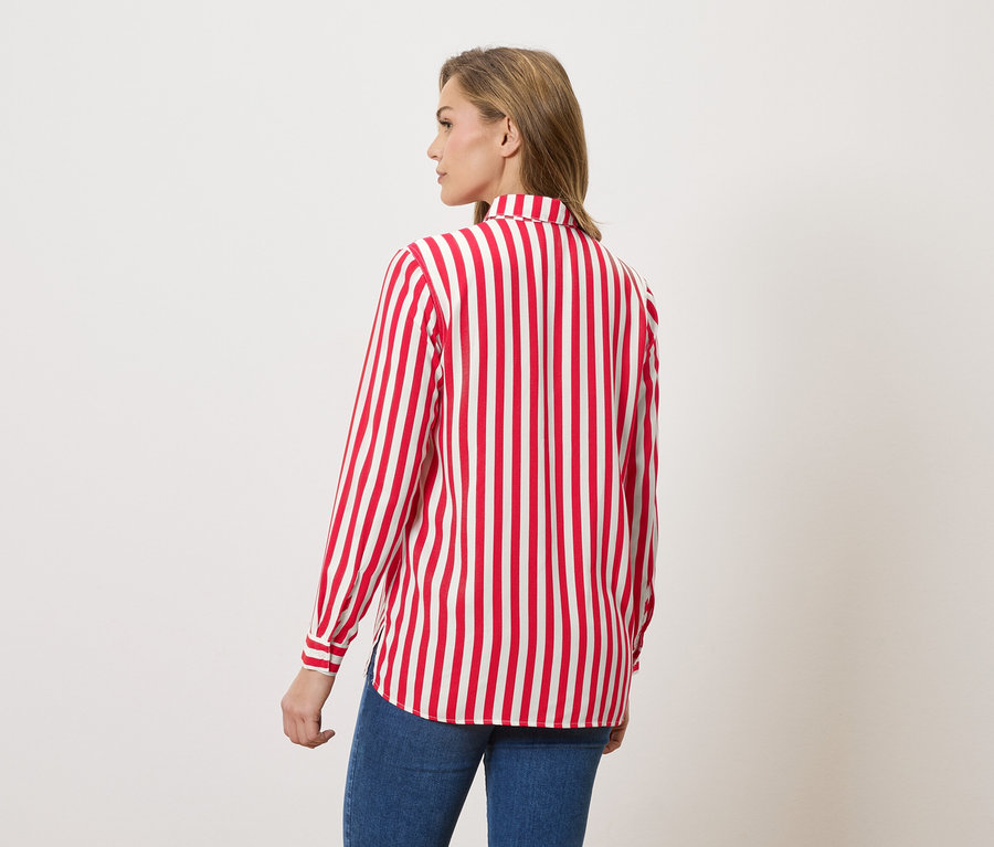 Frau von hinten in rot-weiß gestreifter Bluse und Jeans.