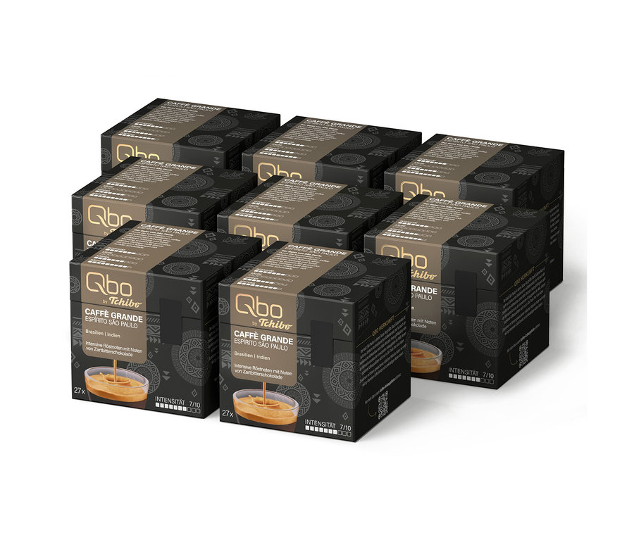 Sechs schwarze Schachteln Qbo Caffè Grande ESPÍRITO SÃO PAULO Kaffeekapseln von Tchibo, jede mit 27 Kapseln, Intensität 7/10 und Noten von Zartbitterschokolade, mit einem Bild von Kaffee in einem Glas.