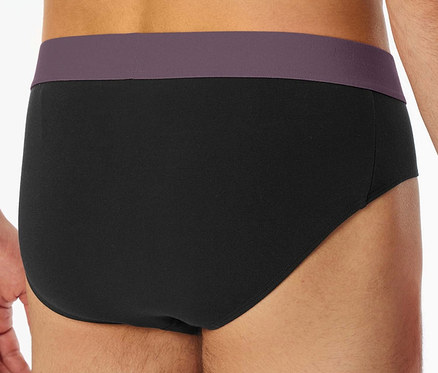 Nahaufnahme der Rückansicht eines Mannes, der schwarze Slips mit lila Bund trägt.