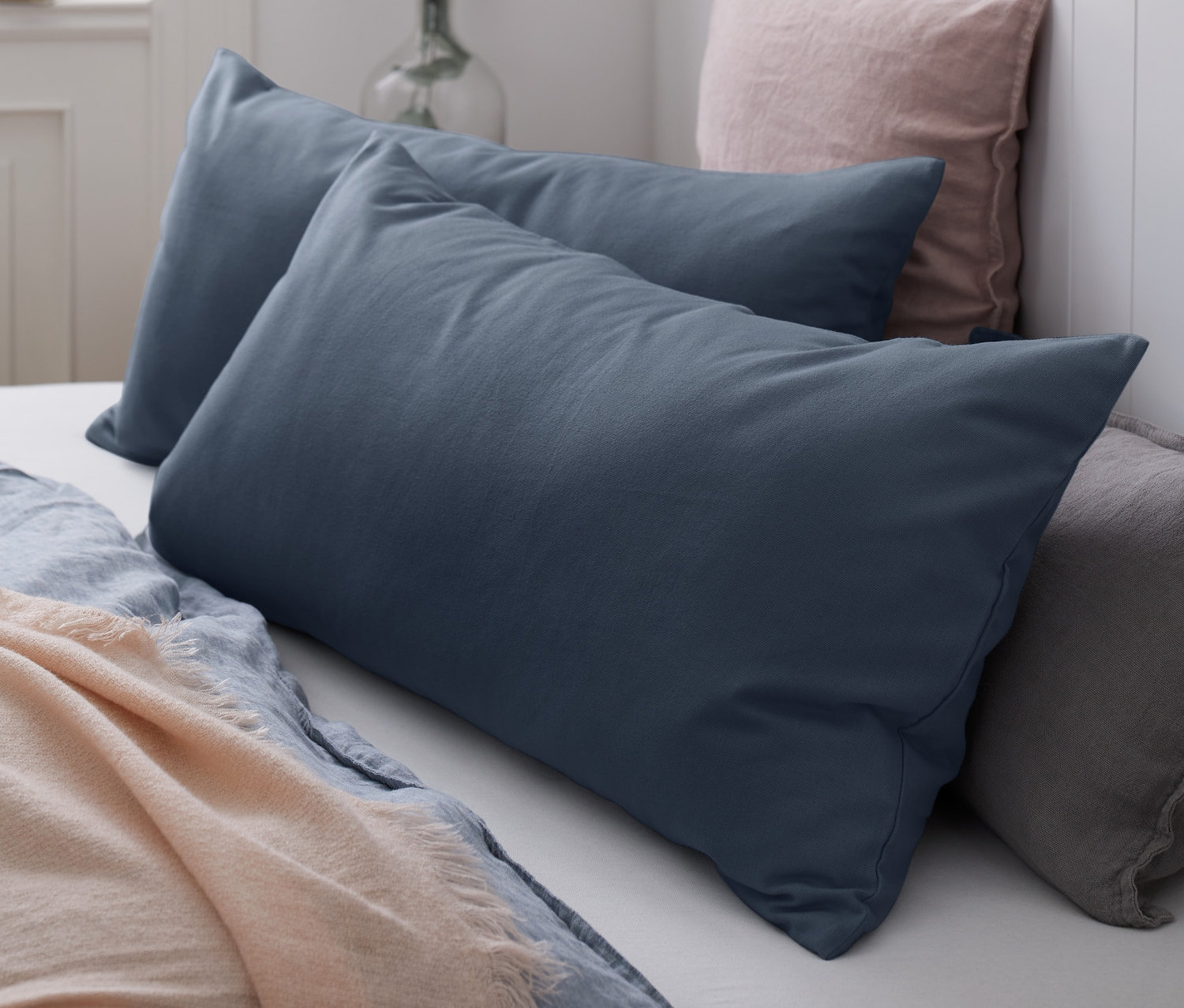 Auf einem Bett liegen zwei blaue Biber-Kopfkissenbezüge.