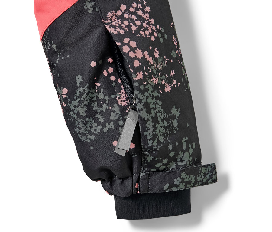 Detailaufnahme einer Kinder-Skijacke mit Blumenmuster und Reißverschluss am Ärmel.