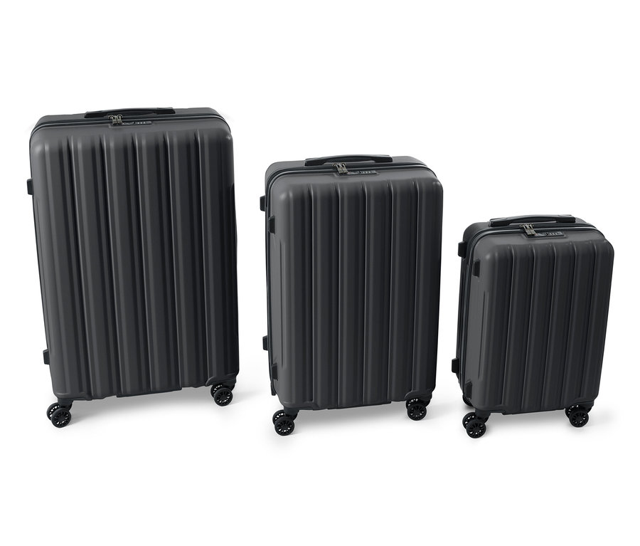 Drei schwarze Hartschalen-Koffer unterschiedlicher Größe nebeneinander.