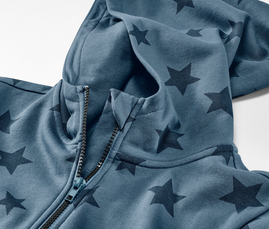Detailansicht eines blauen Kinder-Lounge-Overalls mit Sternen und Reissverschluss.