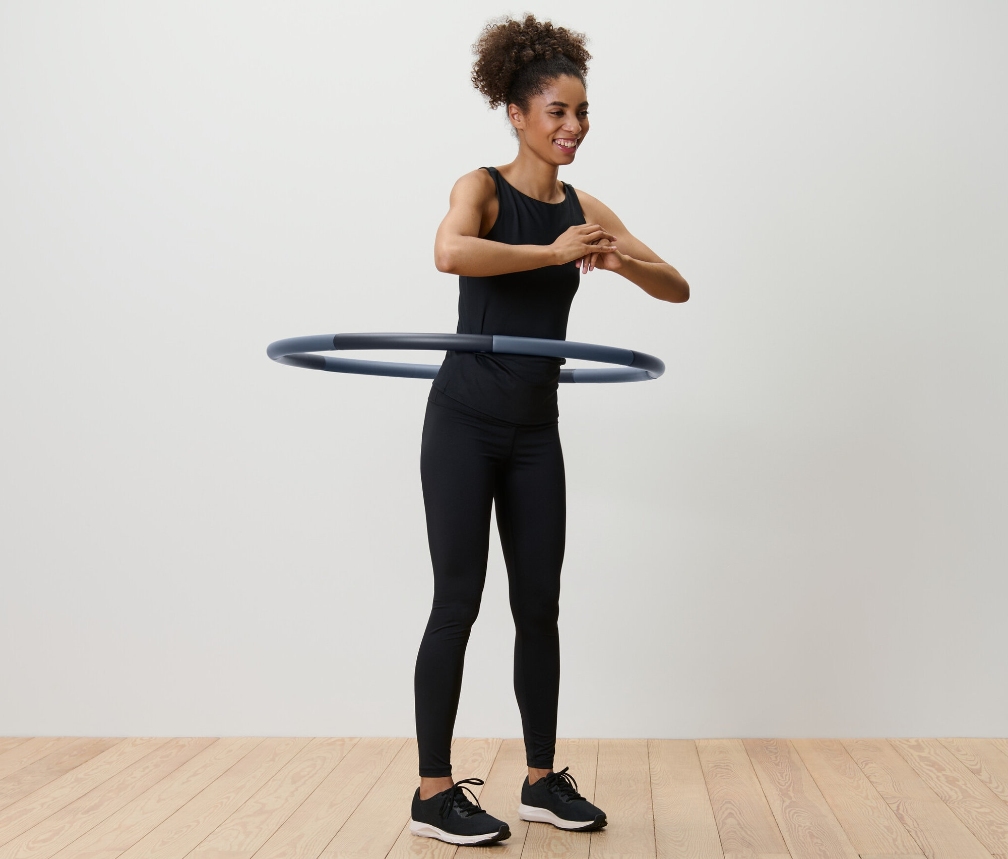 Frau dreht einen Fitnessreifen um ihre Taille.