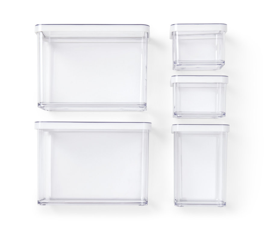 Fünf transparente Vorratsdosen unterschiedlicher Größe mit weißen Deckeln auf weißem Hintergrund.