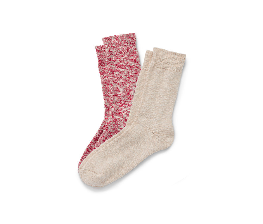 Zwei Paar Stricksocken liegen auf einem weißen Hintergrund.