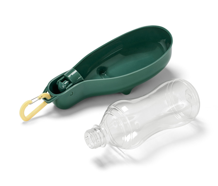 Eine Hunde-Trinkflasche mit integrierter Trinkschale liegt neben einer durchsichtigen Plastikflasche.