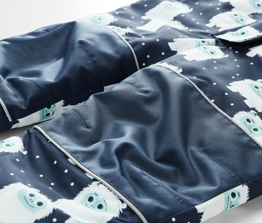 Detail einer blauen Pyjamahose mit weißen Schneemännern und weißen Punkten.