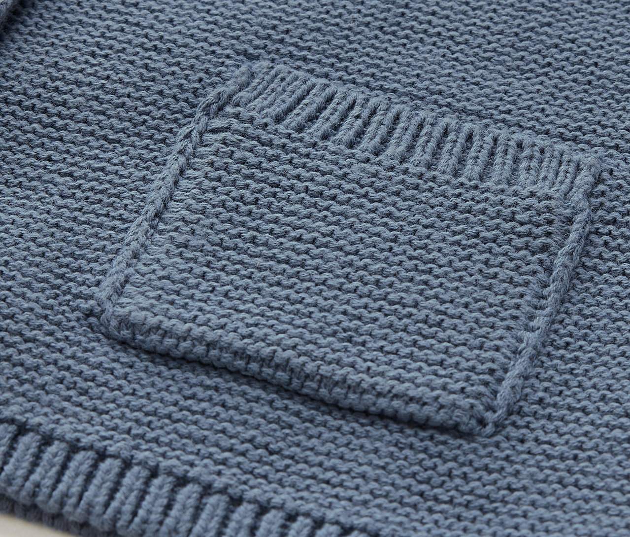 Detail einer blauen Stricktasche.