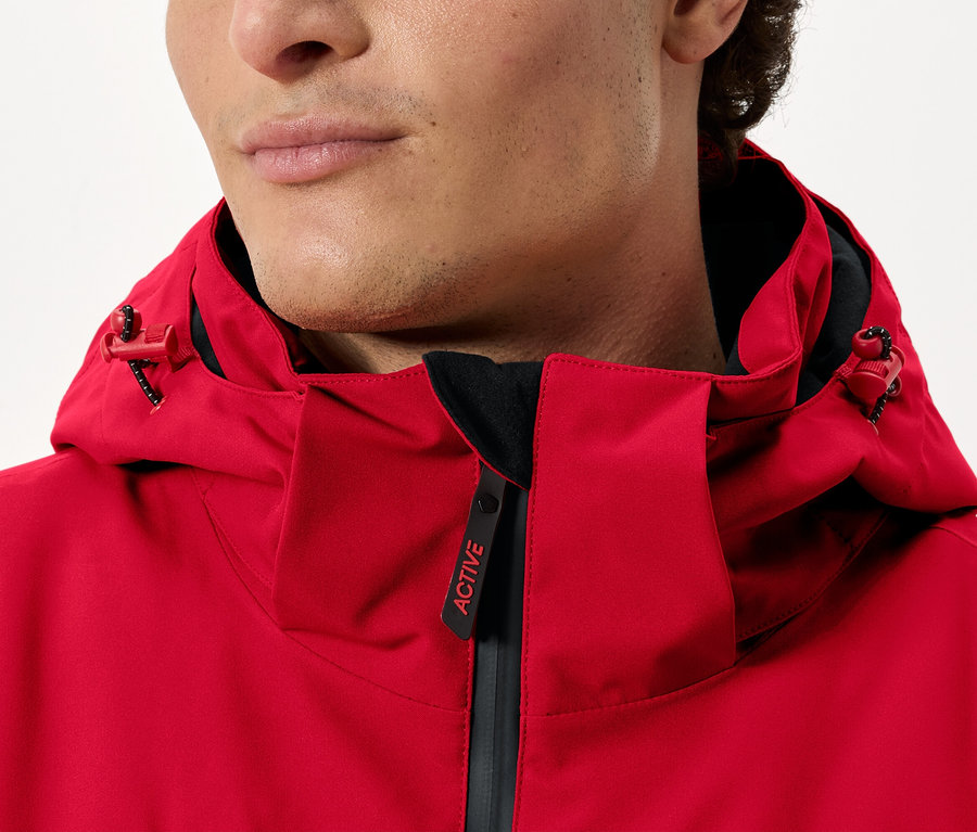 Mann trägt eine rote Jacke mit Kapuze.