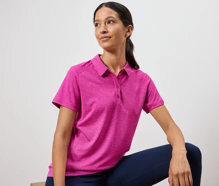 Frau trägt ein pinkes Poloshirt und marineblaue Leggings.