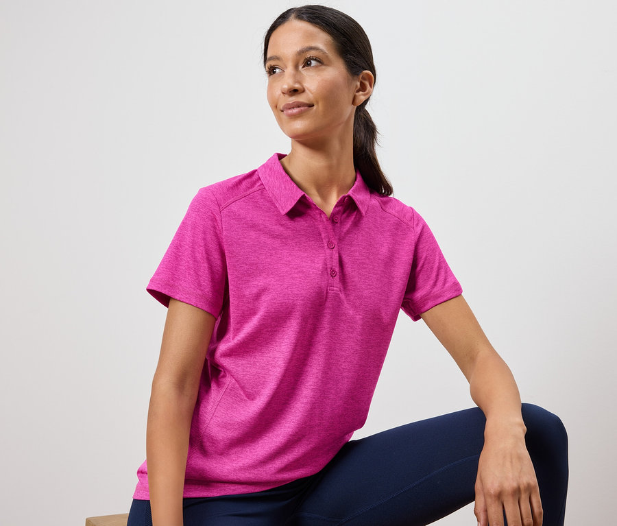 Frau trägt ein pinkes Poloshirt und marineblaue Leggings.